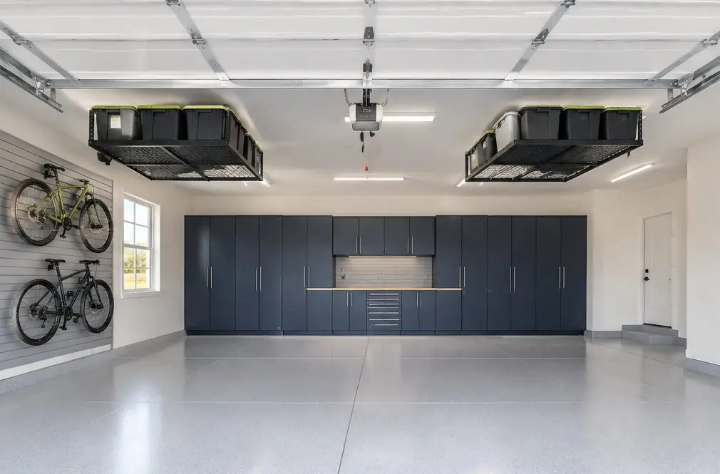 Illustration: a finished three-car garage in a Menifee, CA house, steel cabinets along the back wall of the third bay, slatwall with bikes on a side wall, two overhead racks and a light-gray coated floor