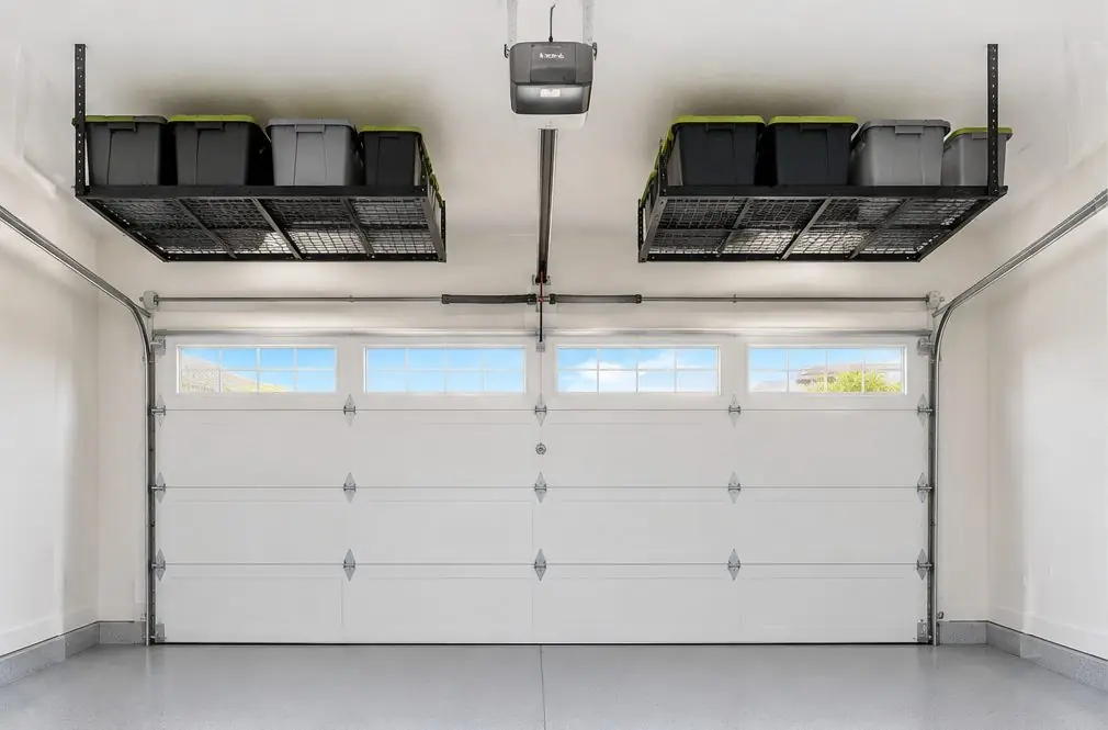 Illustration: two black overhead storage racks above a Menifee, CA garage bay, bins on them, a sectional garage door with its track and the opener rail kept clear beside the racks
